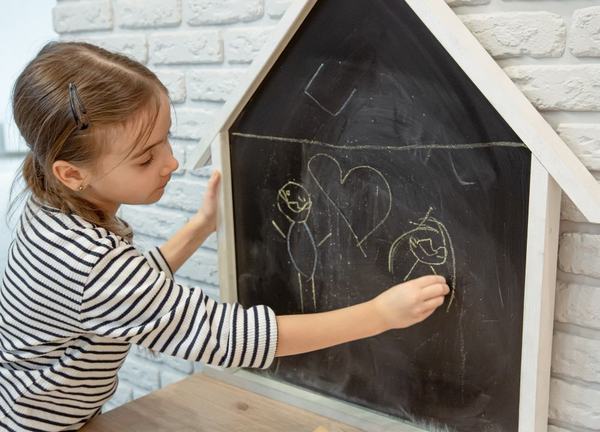 copil care scrie cu creta pe tabla